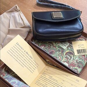 Dooney & Bourke Black Leather wristlet. Still in box, never used.